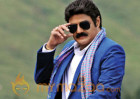 Who's feet does Balakrishna touch?